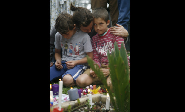 A woman comforts her two sons as they sit around floral tributes laid in memory of Nelson Mandela, at his home in Johannesburg, South Africa. -AP A woman comforts her two sons as they sit around floral tributes laid in memory of Nelson Mandela, at his home in Johannesburg, South Africa. -AP